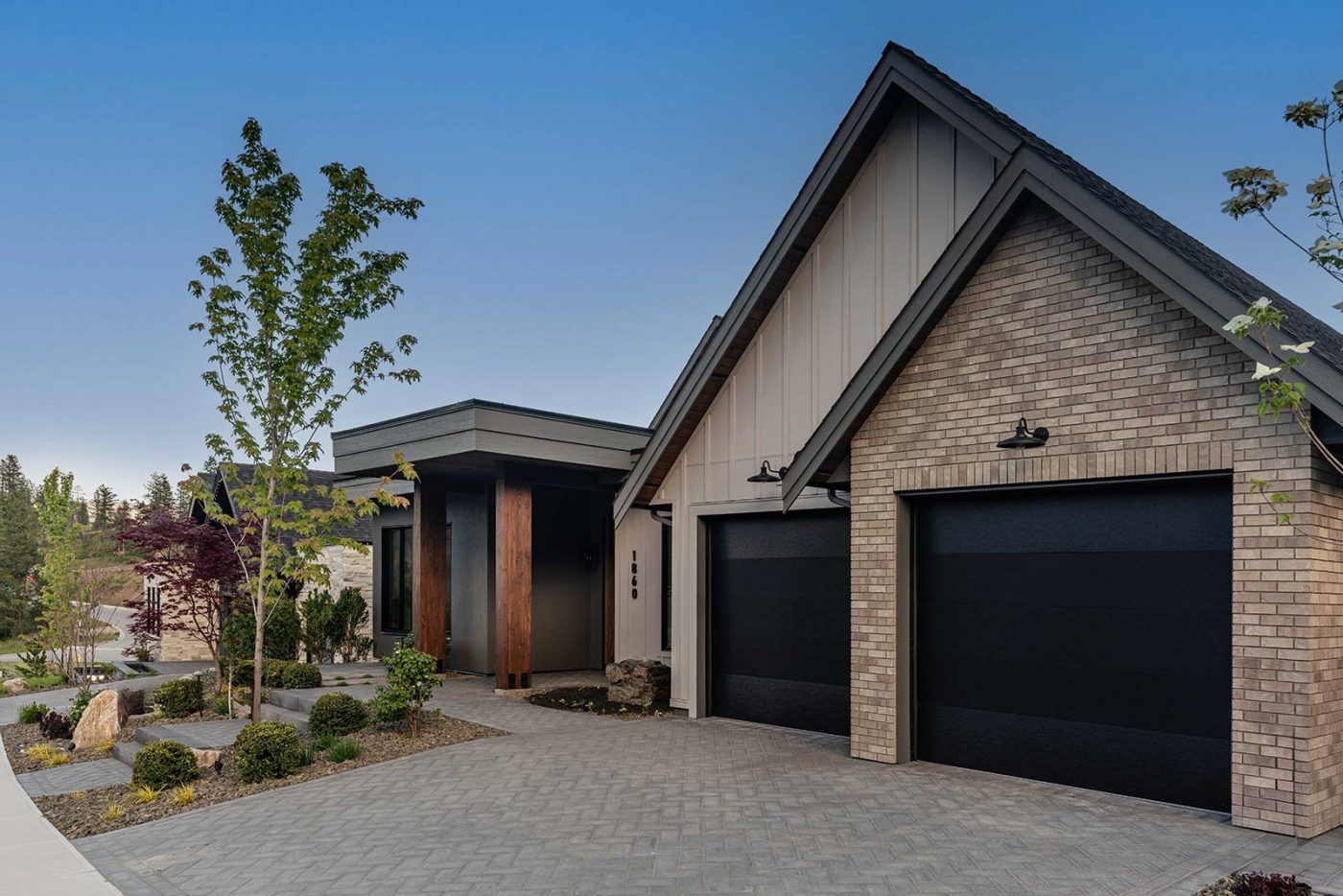 Rykon Hidden Hills showhome exterior with double garage, brick facade, and landscaped driveway in Wilden, Kelowna